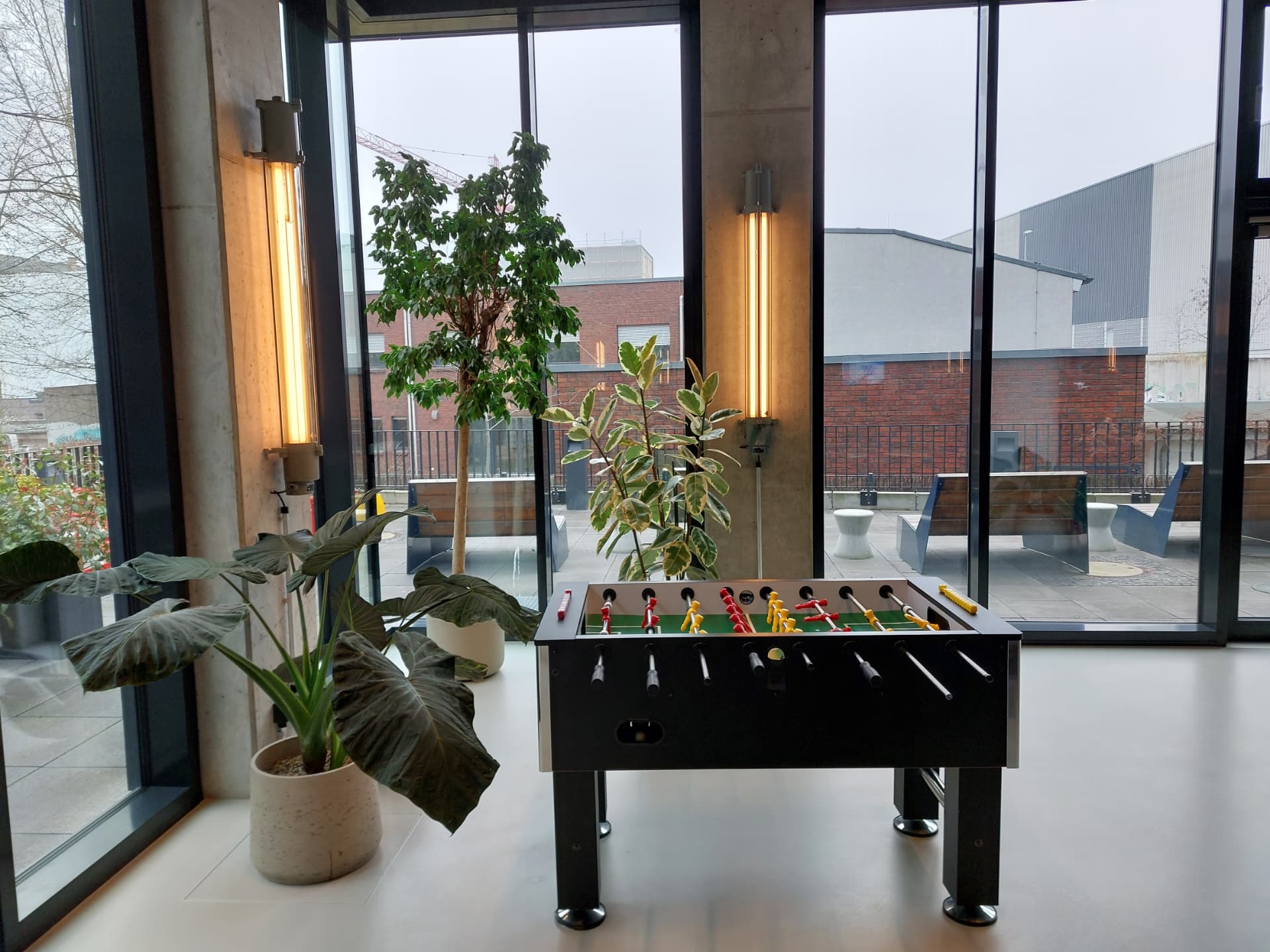 A games table in a plant-filled office breakout space